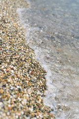 Rock beach and sea, close up on the coast. Water's edge on white stone beach with transparent turquoise sea. Suitable background used