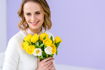 Attractive young woman holding tulips for women's day