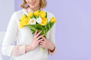 Close-up view of woman holding bouquet of tulips for women's day