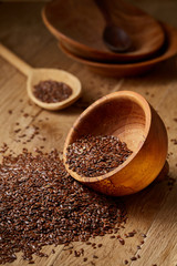 Wooden spoon with flax seeds on rustic background, top view, close-up, shallow depth of field, selective focus