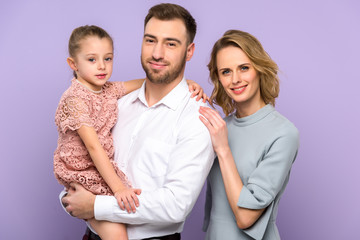 Embracing family with daughter isolated on violet