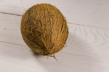 Whole coconut on white wooden table
