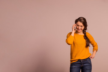 Studio portrait of a young woman with smartphone.
