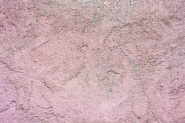 Textured background The outer surface of the wall of a residential house is plastered. Rough texture fancy patterns of ointment on external plastering work of pink color