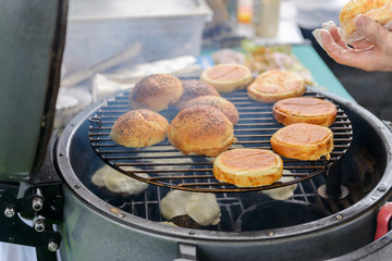 Chef making beef burgers outdoor on open kitchen international food festival event.