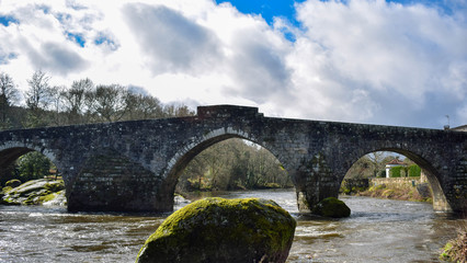 Fototapeta na wymiar puente medieval, río y roca