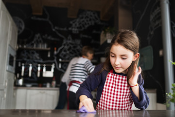 A small girl helping in the kitchen at home.