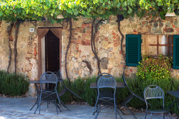 Naklejka na ściany i meble Tables and chairs near the entrance to the old cafe, Italy