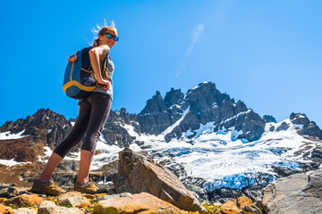 Woman hiker stands on the rocky ground with mountain and glacier on the background. Cerro Castillo...