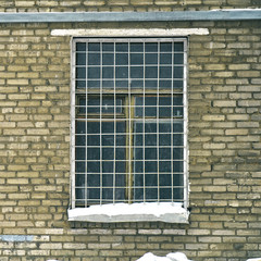 Fototapeta na wymiar Window grille on a window of old soviet brick house
