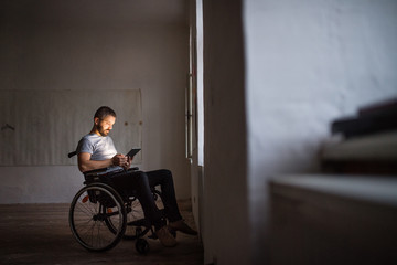Fototapeta na wymiar Man in wheelchair working with tablet.