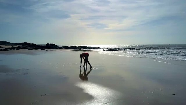 Girl Practises Yoga on Seacoast at Rock Silhouette