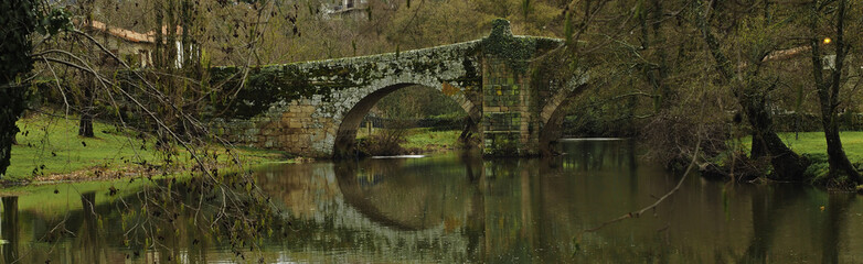 Fototapeta na wymiar Roman bridge reflected in the river