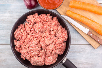 Raw ground meat for bolognese sauce in a frying pan