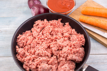 Raw ground meat for bolognese sauce in a frying pan