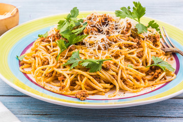 Spaghetti bolognese with cheese close-up on a rustic light background