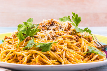 Spaghetti bolognese with cheese close-up on a rustic light background