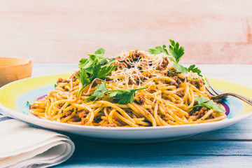 Spaghetti bolognese with cheese close-up on a rustic light background