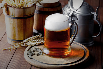 Light foam beer in a glass on an old background