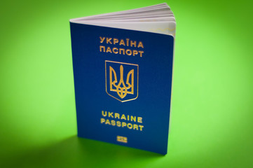One blue biometric ukrainian foreign passport with coat of arms on green background. Visa-free travel concept