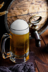 Light foam beer in a glass on an old background