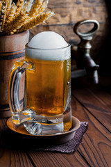 Light foam beer in a glass on an old background