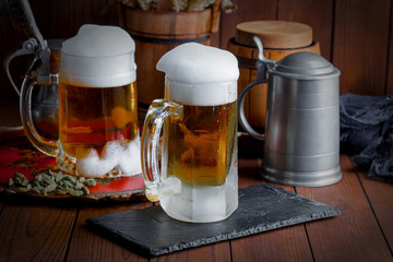 Light foam beer in a glass on an old background