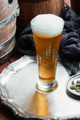 Light foam beer in a glass on an old background