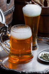 Light foam beer in a glass on an old background