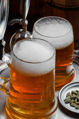 Light foam beer in a glass on an old background