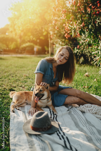 Beautiful Young Smiling Girl Sitting At Sunny City Park With Dog