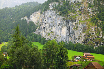 European alpine village near mountains and cliffs, Switzerland
