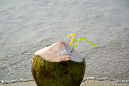 fresh coconut with juice and tubules on the coast of the sea