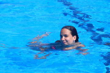 Young beautiful woman relaxing in swimming pool.