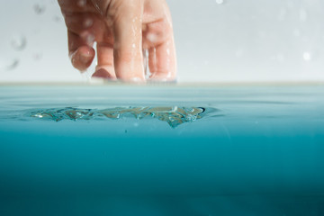 Hand greift ins Wasser zur Abkühlung oder Inspektion