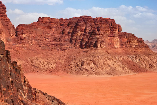 Red mountains of the canyon of Wadi Rum desert in Jordan. Wadi Rum also known as The Valley of the Moon is a valley cut into the sandstone and granite rock in southern Jordan to the east of Aqaba.