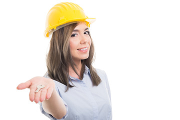 Portrait of female constructor handing door key.