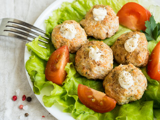 Delicious meatballs with parsley, lettuce and tomato closeup on a plate on the table. horizontal