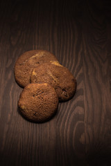 lecker selbst gemachte runde Cookies Kekse American Style mit Schokolade auf Holz im Spotlight Menü Karte