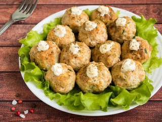 Delicious meatballs with parsley, lettuce and tomato closeup on a plate on the table. horizontal