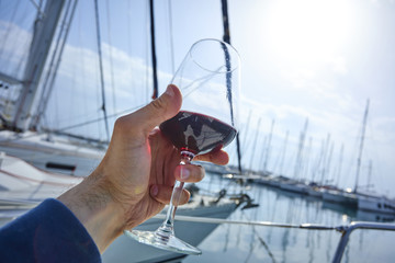 a glass of red wine on the deck of the yacht