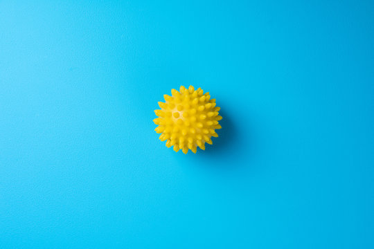 Spiky massage ball on blue background top view. Self massage, healthy, wellness and reflexology therapy concept. Copy space