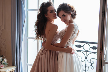 Fototapeta premium Beautiful bride and bridesmaids in luxury dresses. Twins young women in wedding photosession