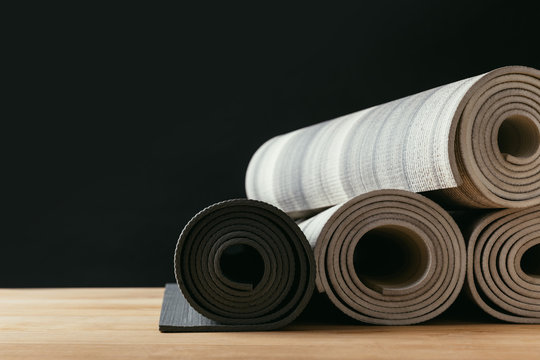 different rolled yoga mats on wooden tabletop
