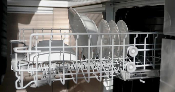 hands take out clean dishware from dishwasher