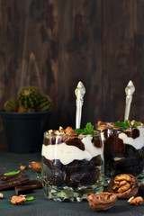 A homemade dessert with vanilla cream, cookies, prunes and nuts.