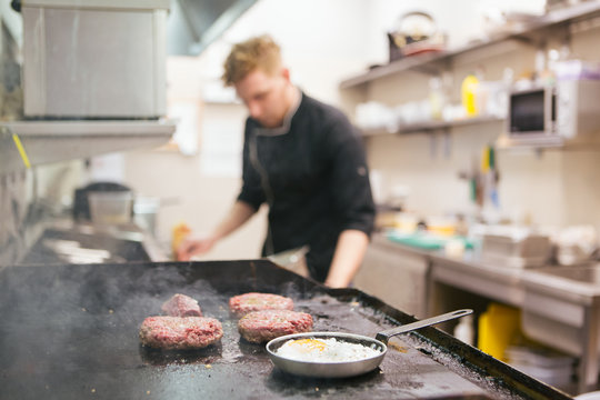 Cook frying patty on kitchen