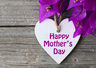 Happy Mother's Day.Pink bougainvillea flowers and decorative heart on old wooden background.Selective focus.