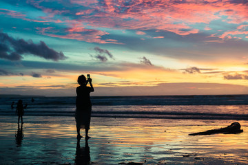Fototapeta premium Silhouettes on a beautiful sunset at the beach.