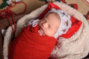 Newborn baby girl sleeping in a vintage, wooden pop crate.